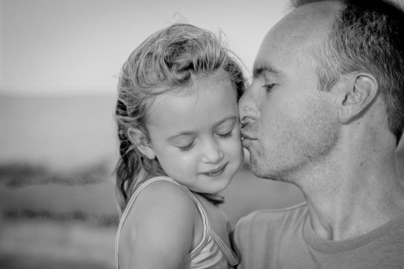 A father kissing his daughter's cheek